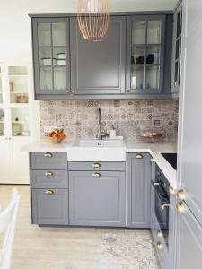 una cucina con mobili blu e un lavandino di The Little White House, Suite Flower Beach 9 a Playa Honda