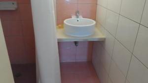 a white sink in a bathroom with pink tiles at Villa Giorgos in Kefalos
