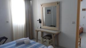 a bedroom with a bed and a mirror on a wall at Villa Giorgos in Kefalos
