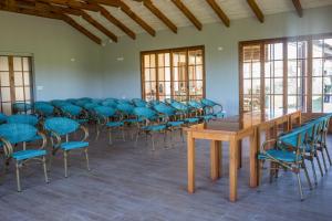 una stanza con sedie blu, tavoli e finestre di Hotel Terraviña a Santa Cruz