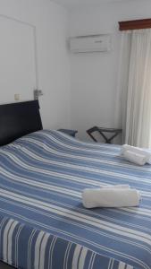 a blue and white bed with two towels on it at Villa Giorgos in Kefalos