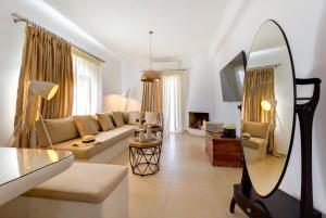 a living room with a couch and a mirror at Santorini’s Diamond Houses in Karterados
