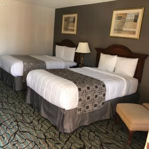 a hotel room with two beds and a chair at Baymont by Wyndham Walterboro in Walterboro +11 photos