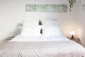 
a white bed with a white comforter and pillows at Easy4Stay in Portimão
