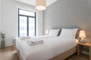 1 dormitorio con 2 camas con sábanas blancas y ventana en FLH Avenida da Liberdade Amazing Flat en Lisboa