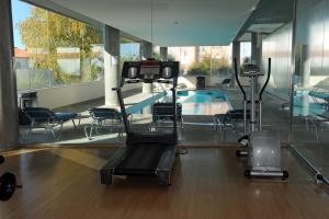 a gym with a swimming pool and exercising machines at Hotel Turismo De Trancoso in Trancoso