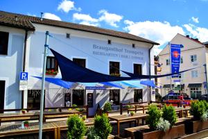 a building with a blue umbrella in front of it at Braugasthof Trompete in Eichstätt