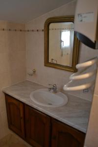 a bathroom with a sink and a mirror at Le Nid au Pied du Mont Ventoux in Malaucène