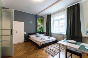 1 dormitorio con cama, mesa y ventana en Prague Apartments en Praga