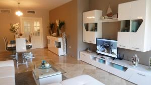 a living room with white cabinets and a flat screen tv at Appartement Hillside Suite in Mijas