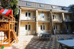 a building with a patio with tables and chairs at Hotel House of the Hunter in Toksovo