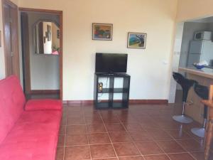 sala de estar con sofá rojo y TV de pantalla plana en Casa Azul, en Vallehermoso