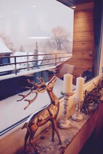 a statue of a deer on a window sill with candles at Chalet am Hasselkopf in Braunlage