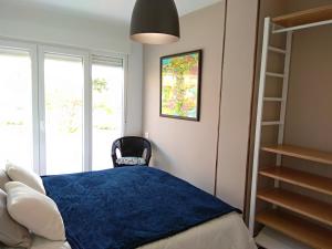 sypialnia z niebieskim łóżkiem i oknem w obiekcie Apartamento a 150 metros del Mar, parking y Wifi w mieście Salobreña