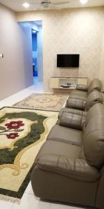 ein Wohnzimmer mit einem Sofa und einem Flachbild-TV in der Unterkunft Hazim Homestay Changlun Pakej Esklusif in Changlun