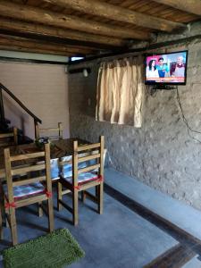 Ayres de Vistalba في سيوداد لوجان دي كويو: غرفة بها كرسيين وتلفزيون على جدار
