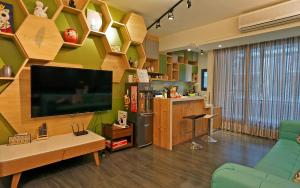 un soggiorno con grande TV e scaffali in legno di Mori Inn a Beipu