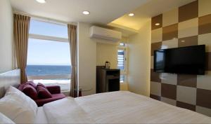 a bedroom with a bed and a flat screen tv at 綠島 綠堤濱海旅店 in Green Island