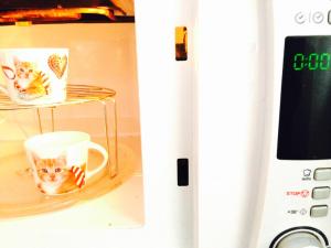 a microwave with two cups in a refrigerator at Valencian Dreams in Valencia