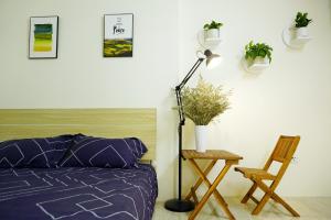 下龍灣的住宿－Hometel Newlife Hạ long，一间卧室配有一张床、一盏灯和一把椅子