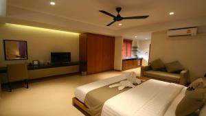 a hotel room with a bed and a ceiling fan at Khaolak Blue Lagoon Resort - SHA Extra Plus in Khao Lak