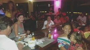 Infinity Sands Resort في سيكويجور: مجموعة من الناس يجلسون على طاولة في مطعم