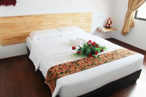 a hotel room with a bed with a flower arrangement on it at AM Transit Inn Kuala Terengganu in Kuala Terengganu