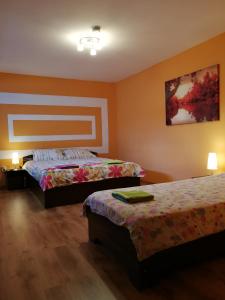 a bedroom with two beds and a painting on the wall at JugendStube Hostel in Braşov