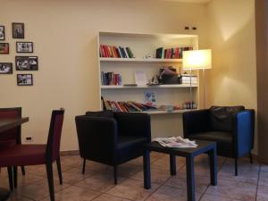 una sala d'attesa con sedie, tavolo e libreria di Albergo Ristorante Protti a Cattolica