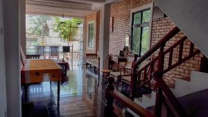 a room with a staircase and a table and chairs at Hikka Urban Stay in Hikkaduwa