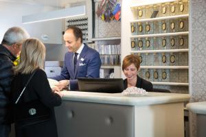 a man and woman standing at a counter in a store at Hotel Helvetia in Genova