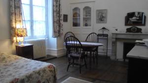 サルラ・ラ・カネダにあるLa Maison du Notaire Royalのテーブルと椅子、暖炉が備わる客室です。