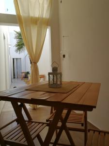 サンニコーラにあるPalmarìのカーテン付きの部屋の木製テーブル