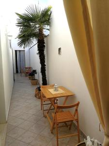 サンニコーラにあるPalmarìのテーブルと椅子、ヤシの木が備わるお部屋