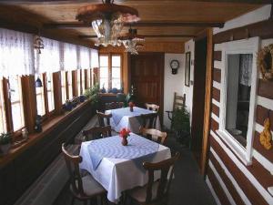 ein Restaurant mit 2 Tischen, Stühlen und Fenstern in der Unterkunft Pension Skalicky in Pec pod Sněžkou