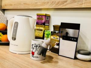 a kitchen counter with a coffee maker and a mug at Piper Cytadela Apartament in Poznań