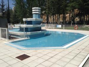 a swimming pool with a fountain in a park at Hotel Náyade in Los Ángeles de San Rafael