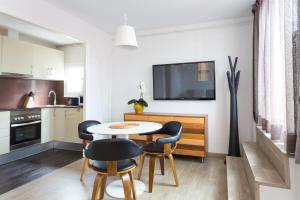 a kitchen with a table, chairs and a refrigerator at Quartprimera Apartments in Barcelona