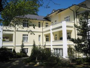 a large white building with trees in the foreground at Villa Caprivi - 12 in Heringsdorf +12 photos