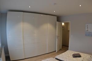 ein Schlafzimmer mit einem großen weißen Schrank und einem Bett in der Unterkunft Ferienhaus Rosi in Kiel