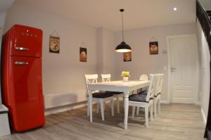 a kitchen with a table and chairs and a red refrigerator at Ferienhaus Rosi in Kiel