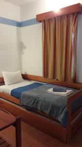 - une chambre avec un lit et une tête de lit en bois dans l'établissement Beach Apartment in Cabanas de Tavira, à Tavira