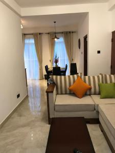ヌワラエリヤにあるRegal Rose Luxury Holiday Apartmentsのソファとテーブルのあるリビングルーム