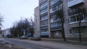 an empty street with cars parked next to a building at Bon Voyazh in Velikiye Luki