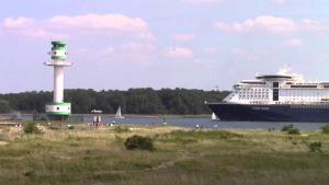 a cruise ship in the water next to a lighthouse at Ferienhaus Rosi in Kiel