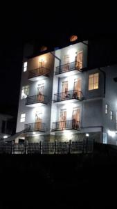 a lit up building with balconies at night at Regal Rose Luxury Holiday Apartments in Nuwara Eliya