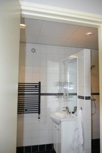 Baño blanco con lavabo y espejo en Vakantiewoning De Berkeboom, en Winterswijk