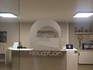 un ufficio con bancone della reception e arco di Palazzo Ossuna a Trapani