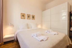 una camera da letto bianca con due asciugamani su un letto di City Center Nice, 2 bedrooms, 2 balconies, AC a Nizza