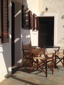 een patio met stoelen, een tafel en een deur bij Casa di Mare in Palekastron